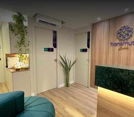 Recepção da Transmutar, com balcão em mármore verde e o logo na parede de madeira